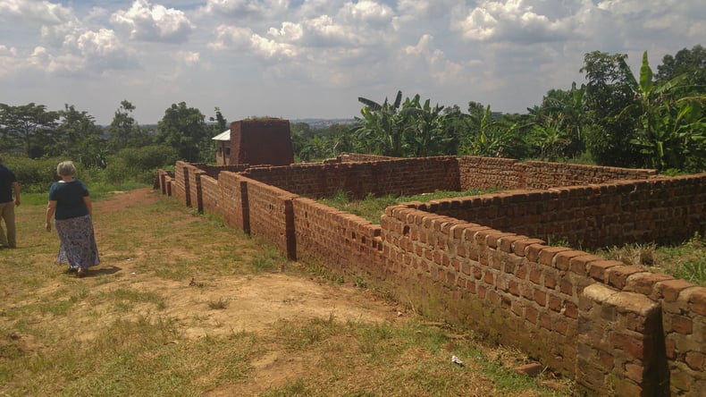On Day 6, the team visits a project that has not started yet. Here stands the start of a classroom block, but the grass is overgrown showing signs of abandonment. The project requires more money and help to finish construction.